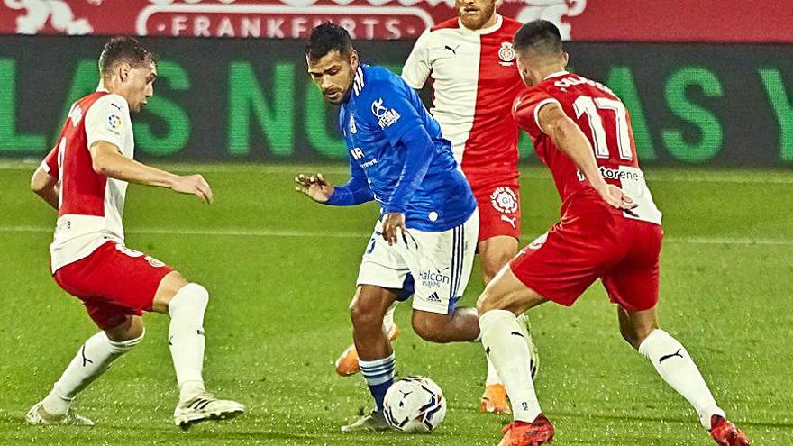 Nahuel, con el balón, trata de irse de dos rivales del Girona. | LOF