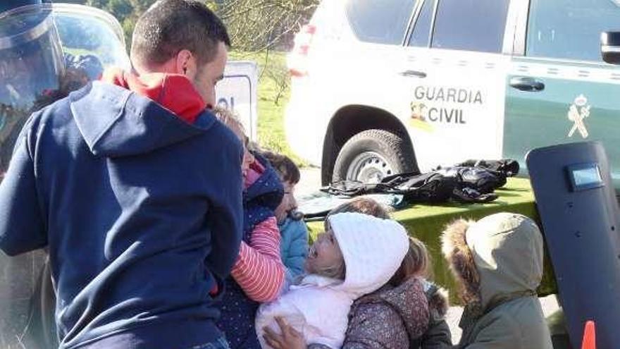 Los alumnos empujan, entre carcajadas, a un agente antidisturbios ayudados por un maestro.