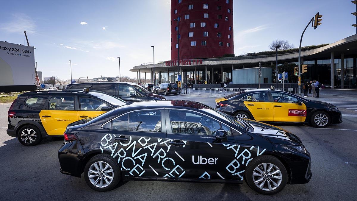 Taxis y un coche de Uber circulando cerca de la Fira de Barcelona.