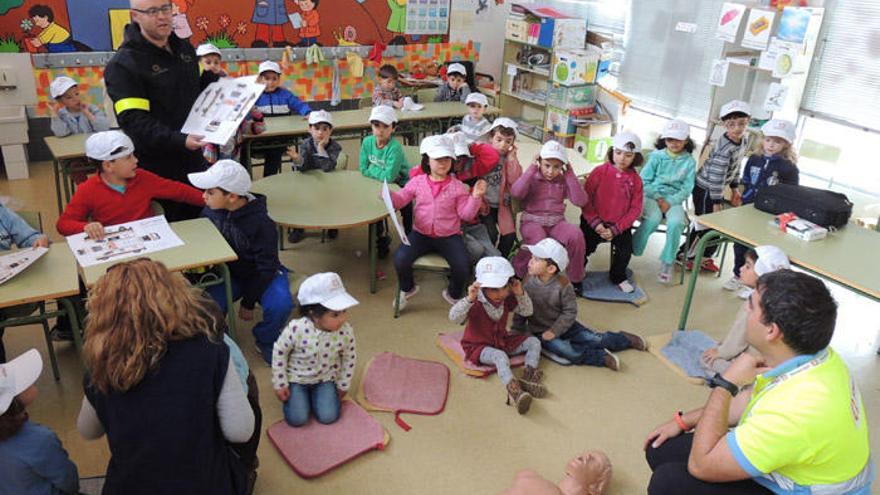 Dos monitores instruyen a los pequeños en las maniobras de primeros auxilios.