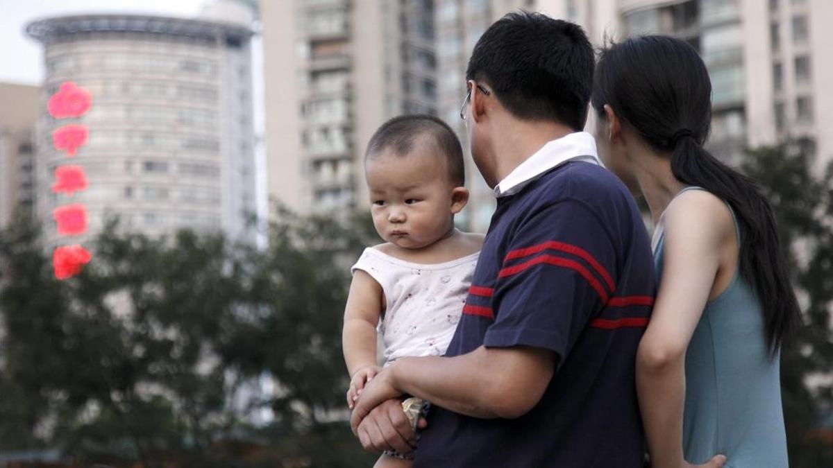 CHN01  SHANGAI (CHINA)  26 07 09 - Una pareja observa a unos ninos jugando en un parque cargando a su bebe este 27 de julio de 2009  en Shangai (China)  Las autoridades de Shangai  la ciudad mas desarrollada economicamente en China  han exhortado a las parejas que son adecuadas para que tengan un segundo hijo en un intento por reducir el rapido envejecimiento de la poblacion de esta ciudad  segun informan medios estatales  Oficiales de planificacion familiar y voluntarios visitaran a las parejas cuyos miembros sean ambos hijos unicos para animarlos a tomar ventaja de la excepcion a la regla china de solo tener un hijo  segun informa el diario China y otros medios locales  EFE QILAI SHEN