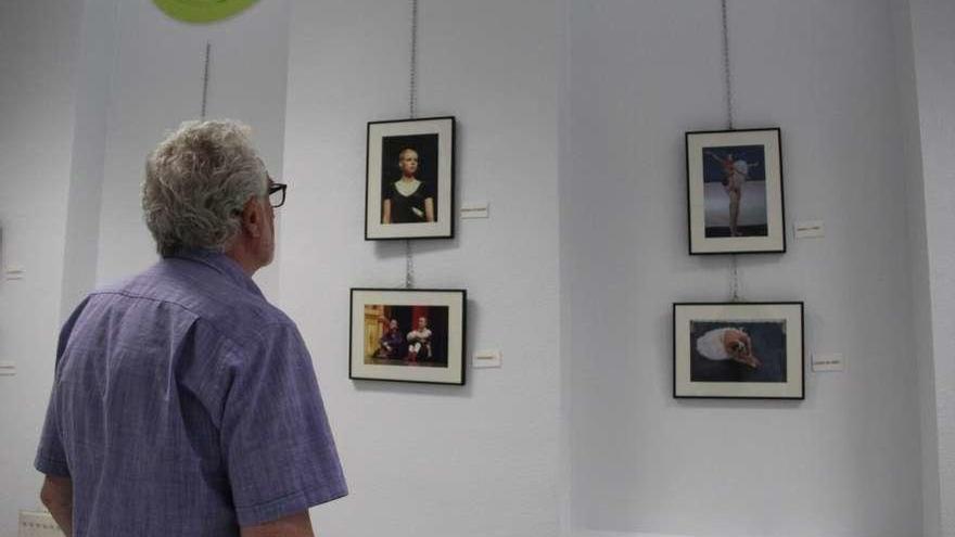 Un hombre admira algunas de las fotografías que conforman la exposición de Martín Ferrero.