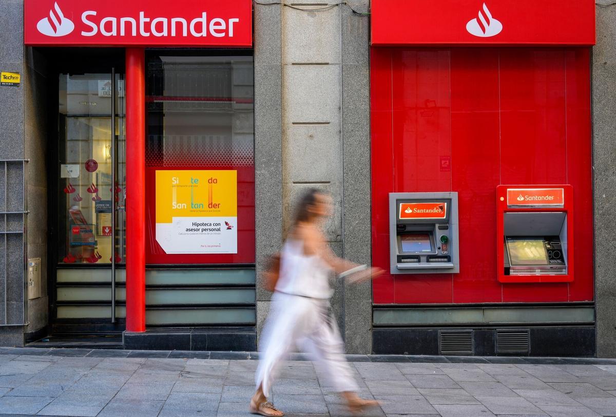 Una mujer pasa frente a una sucursal bancaria.