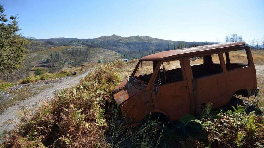 Madera quemada, vehículos calcinados y un monte rocoso conforman después de un año del fuego el paisaje habitual de Ponte Caldelas. // Ponte Caldelas