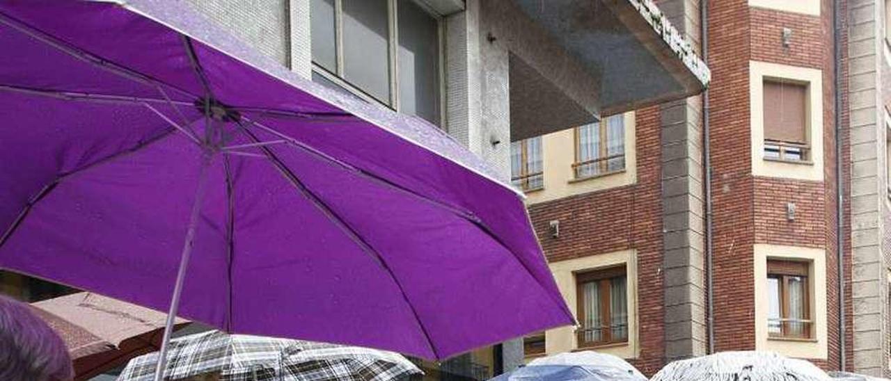 Turistas bajo la lluvia durante una visita guiada en Avilés.