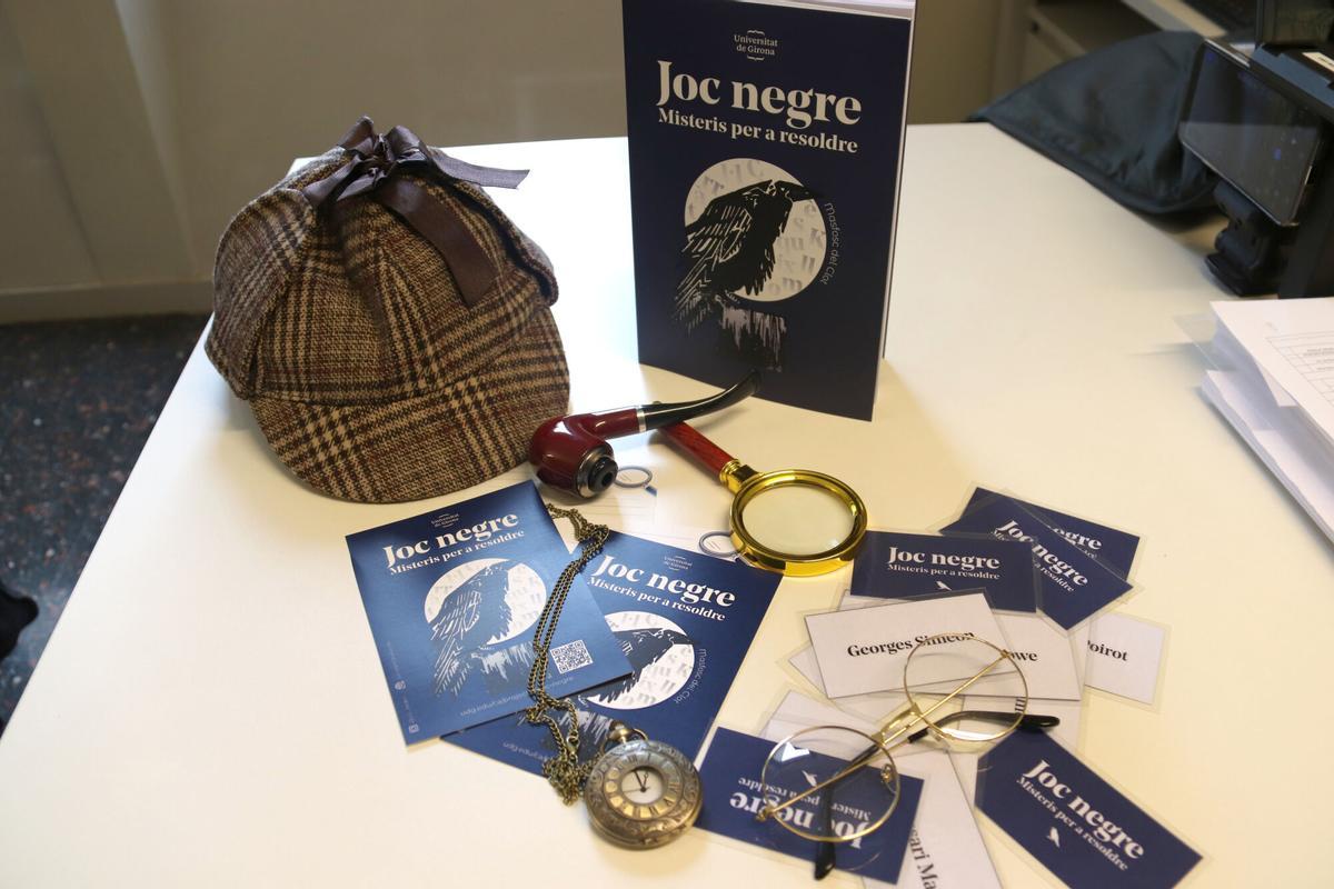 El llibre de misteris educatius de la UdG 'Joc negre' amb materials diversos que ajuden a treballar els conceptes i també elements d'atrezzo