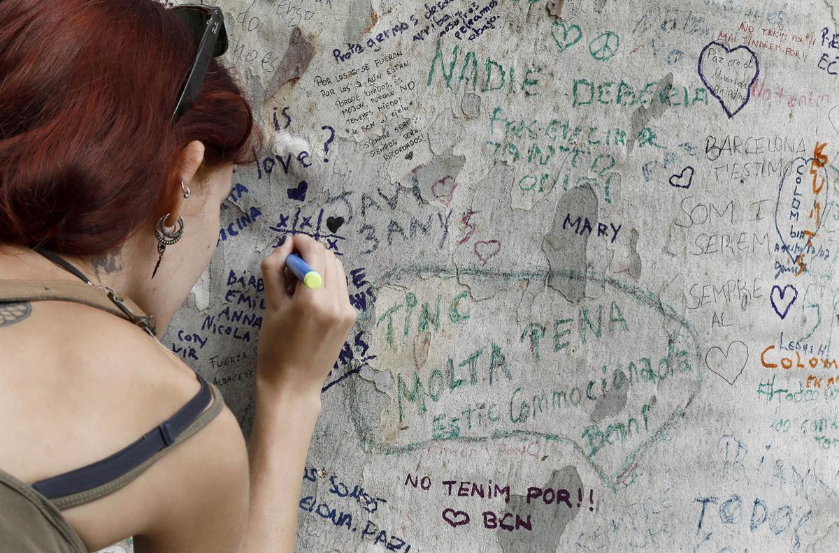 GRA241. BARCELONA, 20/08/2017.- Una persona muestra sus condolencias con uin mensaje escrito en un árbol de Las Ramblas de Barcelona donde una furgoneta causó la muerte a 14 personas y heridas a alrededor de un centenar, en el atentado terrorista ocurrido el pasado jueves. EFE/Andreu Dalmau