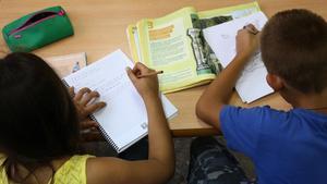 Dos niños de primaria haciendo deberes en su casa, después del colegio.