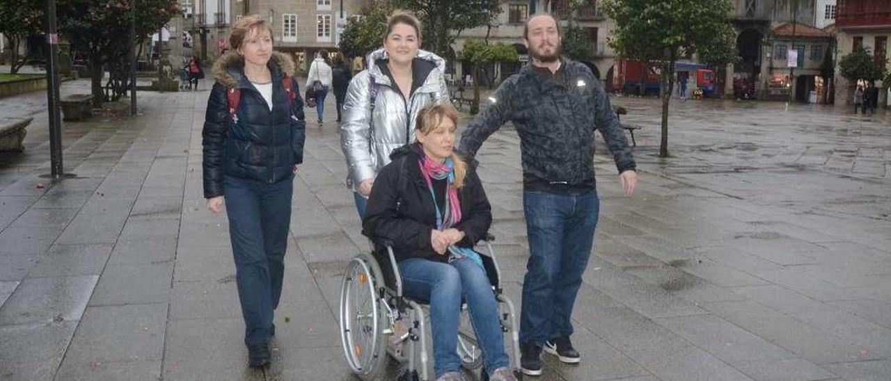 Andrés Rodiño y las estudiantes polacas en A Ferrería, que usaron una silla de ruedas para estudiar la accesibilidad de la ciudad. // R.Vázquez
