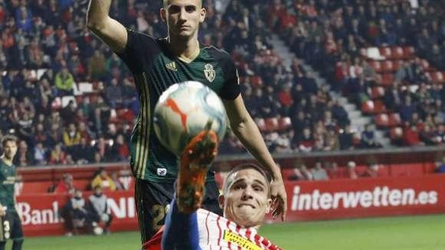 Djurdjevic trata de controlar un balón en presencia de Russo durante el partido de ayer en El Molinón.