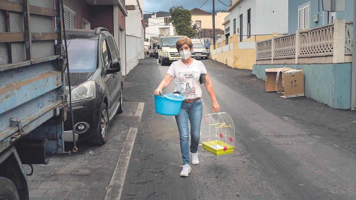 Habitantes desalojados del barrio de La Laguna, el pasado martes, que abandonan sus casas escoltados por las fuerzas de seguridad.