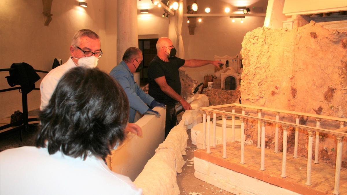 Los Belenistas trabajando en la maqueta en el Palacio de Guevara, este jueves