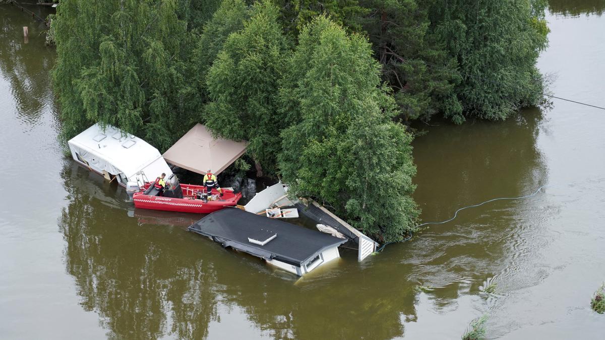 Bomberos inspeccionan unas caravanas arrastradas por la inundación causada por las fuertes lluvias en Fagernes, en Noruega, este viernes.