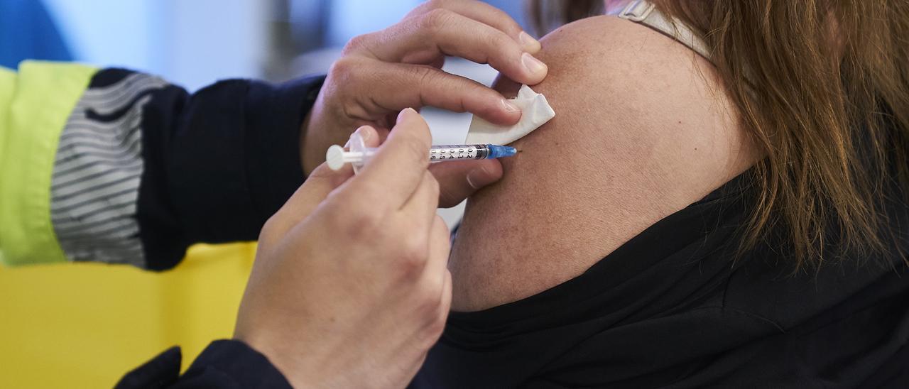 Un sanitario vacuna a una mujer con la dosis de Pfizer.