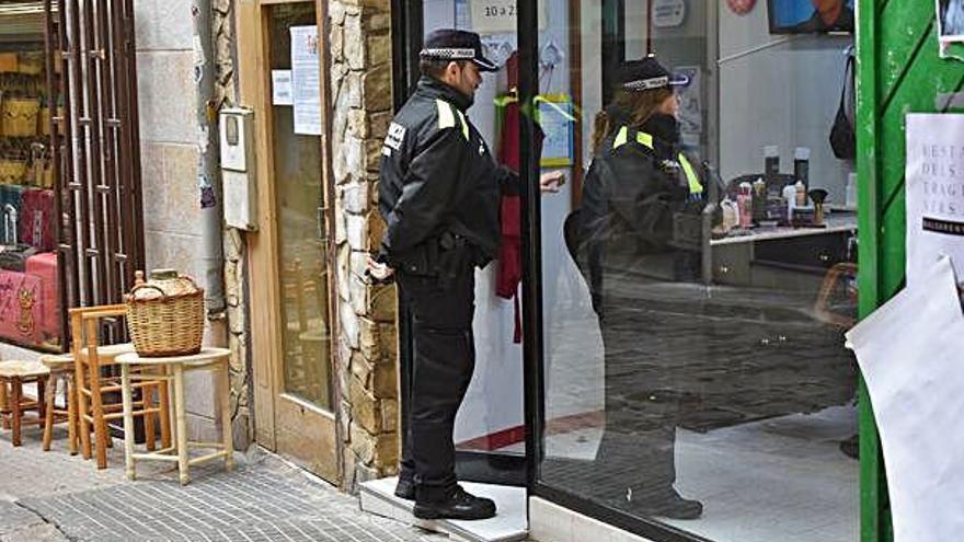 La parella de la Policia Local entrant en un local del carrer Major