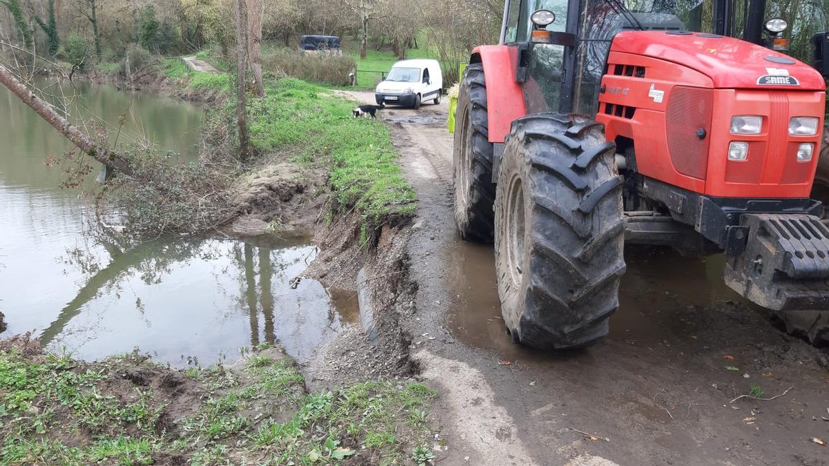 Un tractor y una furgoneta circulan por el camino amenazado por el río Nora.