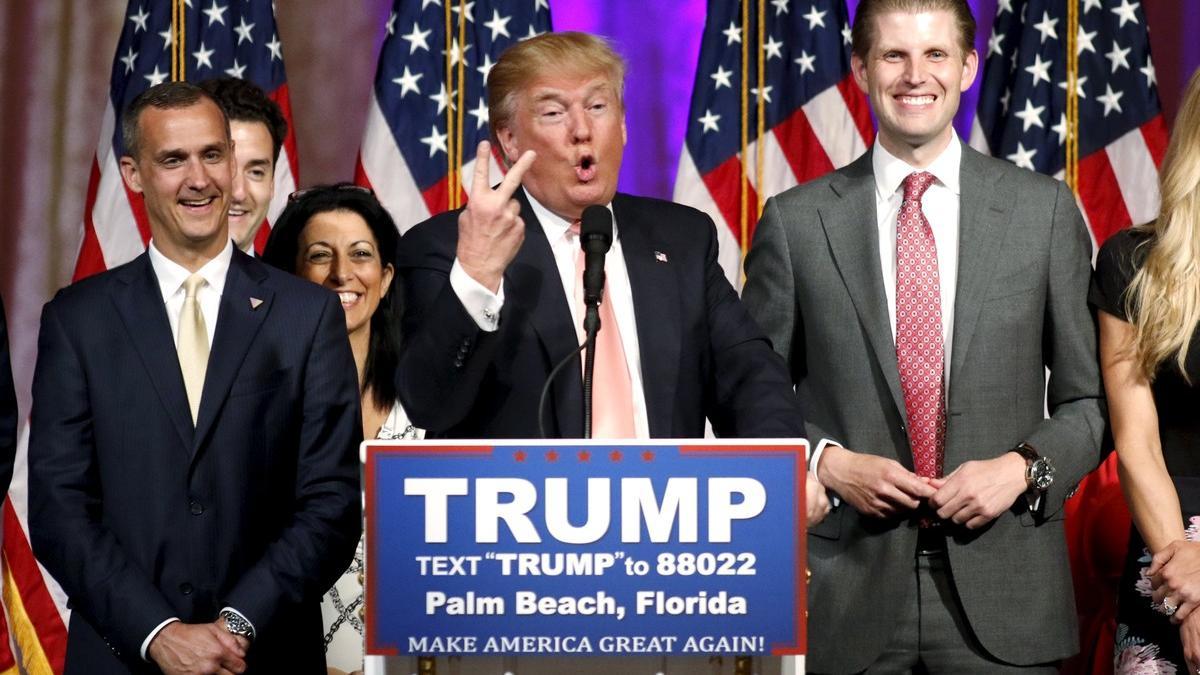 Donald Trump, flanqueado por su jefe de campaña, Corey Lewandowski (izquierda) y su hijo Eric (derecha), habla de los resultados de las primarias, anoche en Palm Beach (Florida).