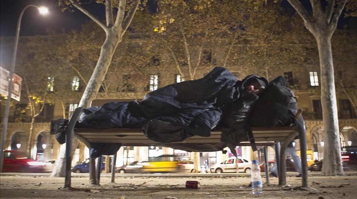 Un sintecho duerme en el parque de la Ciutadella. 