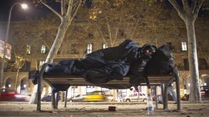 Un sintecho duerme en el parque de la Ciutadella. 