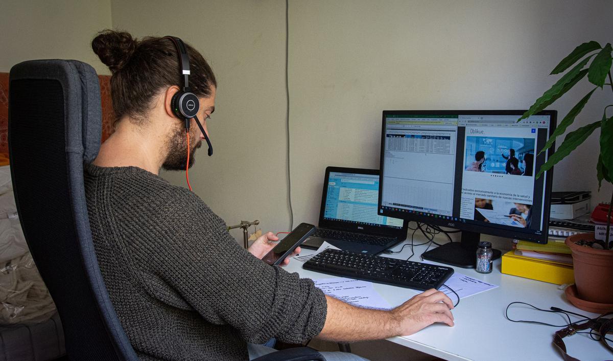 Un joven teletrabajando para una consultora farmacéutica, desde su casa.