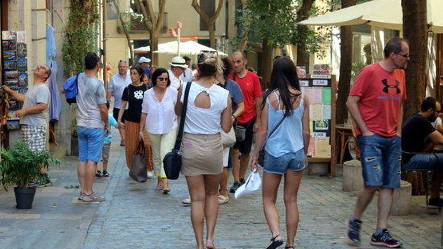 Un grup de turistes caminant pel carrer de la Força de Girona