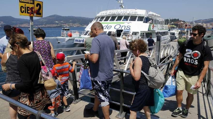 Turistas se dirigen a uno de los barcos que les llevará a Cíes desde el Puerto de Vigo. // Alba Villar