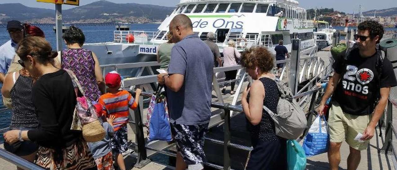 Turistas se dirigen a uno de los barcos que les llevará a Cíes desde el Puerto de Vigo. // Alba Villar