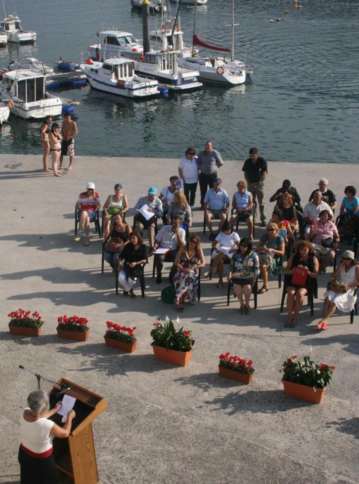 Los participantes en las jornadas, leyendo sus poemas en el puerto de Candás.