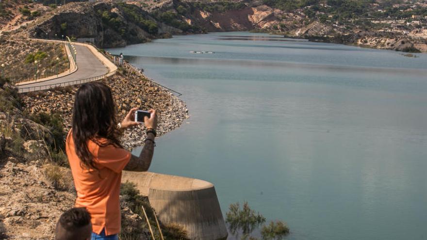 Una chica haciendo fotografías al Pantano de Crevillent, donde llega el agua del trasvase Tajo-Segura para los regantes.