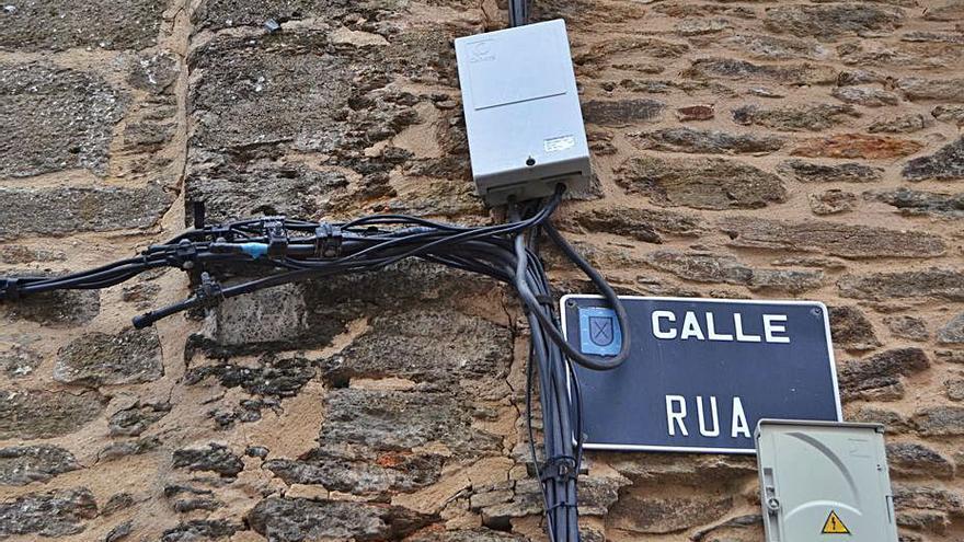 Nudo de cables negros y caja de registro en la calle Rúa de Puebla. | A. S.