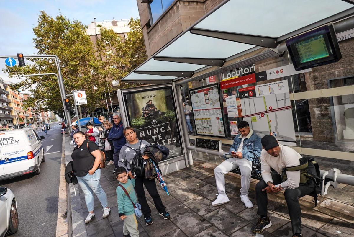 Varios usuarios del transporte público esperan desde hace horas a su bus en la parada de enlace de la estación de tren de Gavà