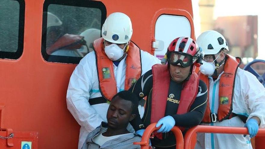 Nada más llegar al puerto de Málaga a bordo de la Guardamar Polimnia, los 15 inmigrantes, la mayoría con hipotermia, fueron atendidos por los voluntarios de Cruz Roja. Siete de ellos fueron trasladados a centros hospitalarios por presentar, además, síntomas de hiperglucemia y tensión baja. Una vez dados de alta serán trasladados a la Comisaría Provincial. En la última foto, uno de los cadáveres recuperados en alta mar.