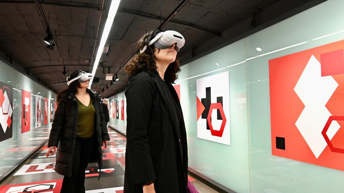 Dos visitantes viajan a bordo de un virtual vagón en la estación de Diagonal.