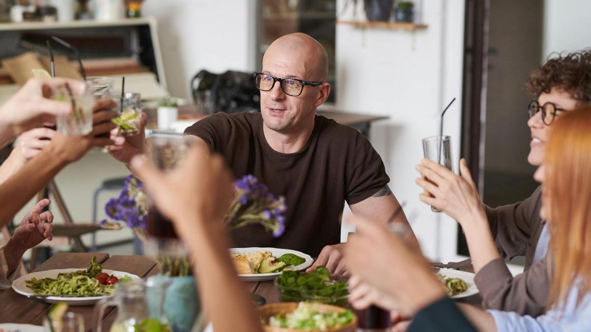 Un grupo de personas brinda y come en un restaurante