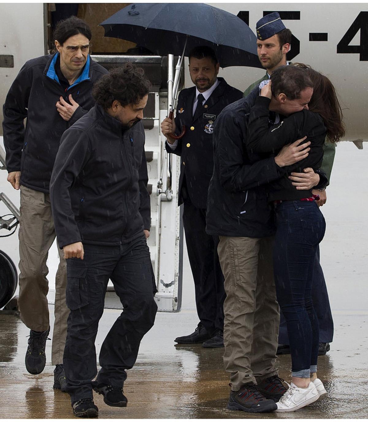 GRA025. MADRID, 08/05/2016.- Fotografía facilitada por la Presidencia del Gobierno de los periodistas españoles Ángel Sastre (c), José Manuel López (i) y Antonio Pampliega (d, abrazando a un familiar), a su llegada esta mañana a la Base äerea de Torrejón de Ardoz, en Madrid, tras ser liberados ayer en Siria, donde permanecían secuestrados en Alepo desde julio del año pasado. EFE/Diego Crespo