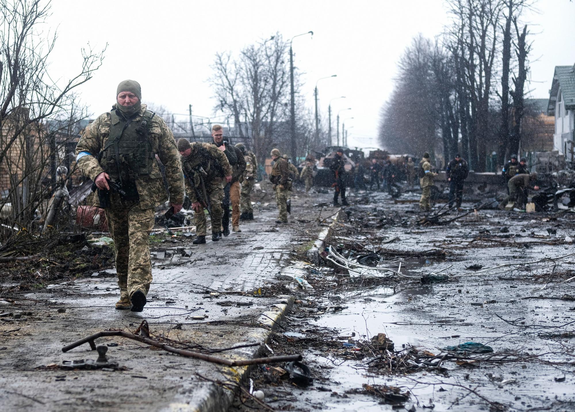 Soldados ucranianos transitan por las ruinas de Bucha.
