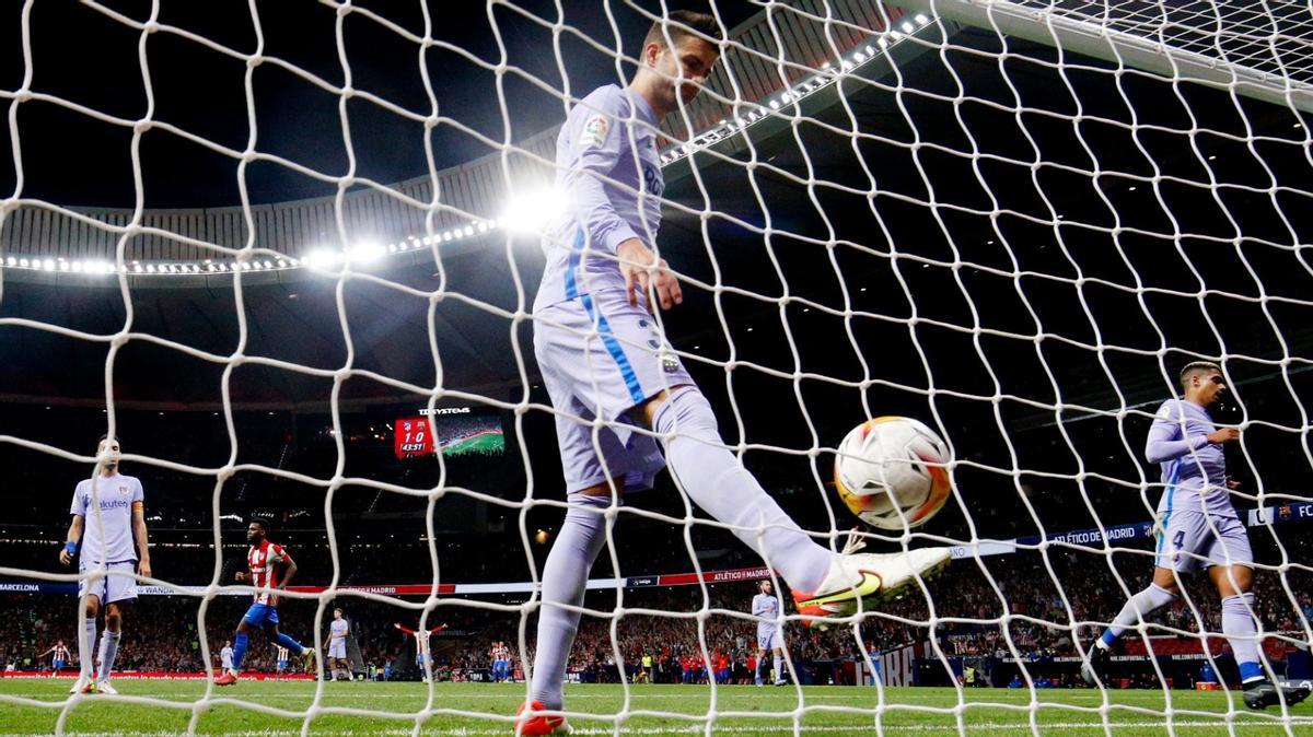 Piqué recoge el balón de la red de Ter Stegen tras el 2-0 del Atlético, marcado por Luis Suárez.