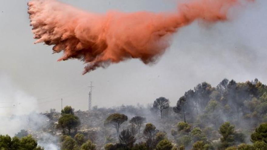 Una avioneta arroja retardante en la montaña de Santa Anna para evitar la propagación del incendio forestal que se ha declarado esta mañana en el término de Gandia.