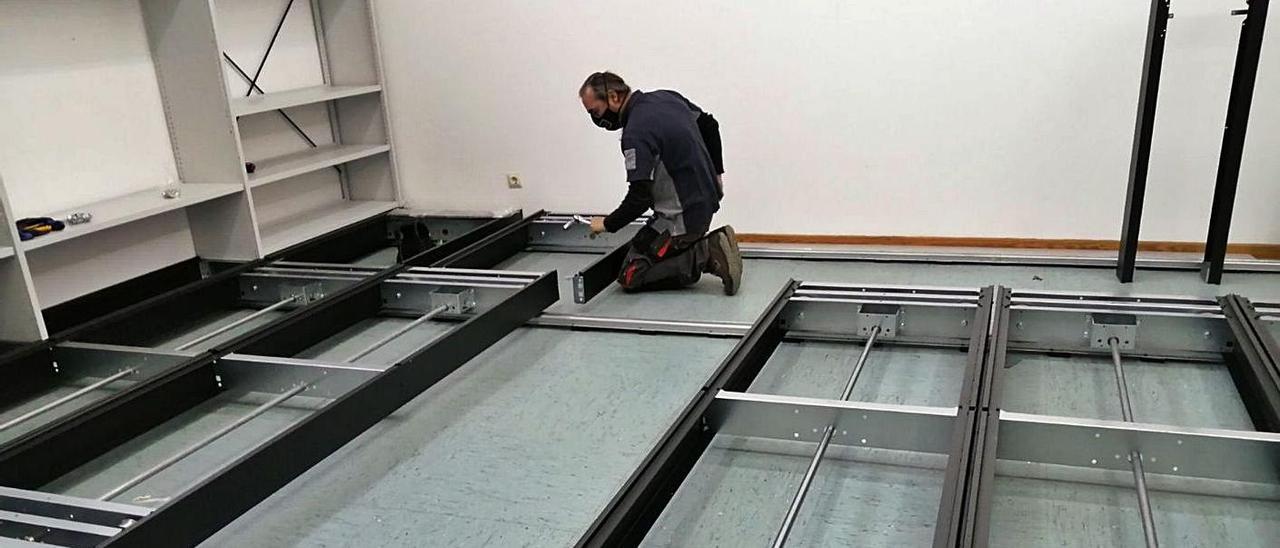 Un operario trabajando ayer en la colocación de los estantes móviles.