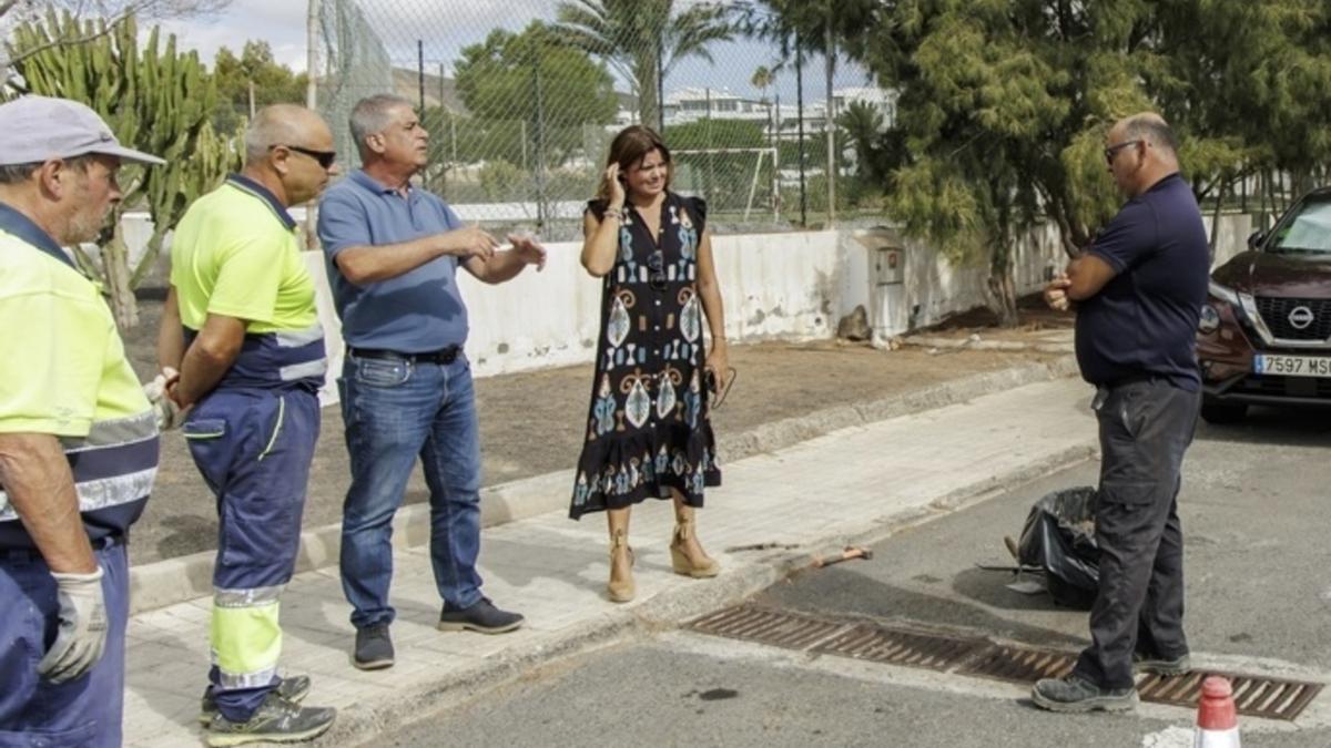 Olivia Duque, junto a Eugenio Robayna y varios operarios junto a una alcantarilla en Costa Teguise