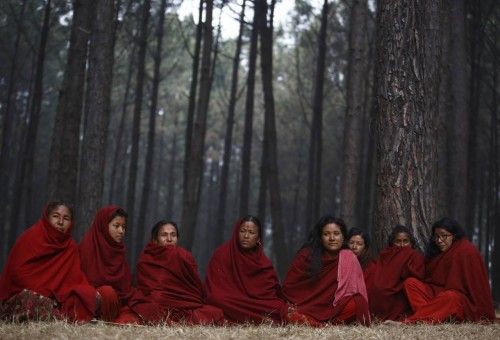 Menstruating devotees sit apart from other devotees while performing rituals and prayers, during the Swasthani Bratakatha festival at the woods of Changu Narayan in Bhaktapur