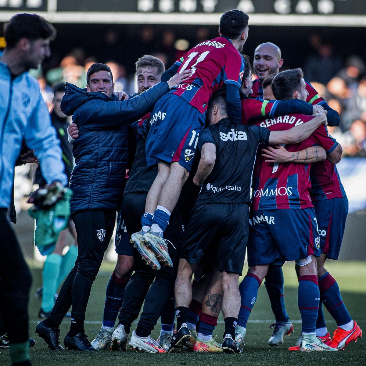Los futbolistas y el cuerpo técnico del Huesca celebran su victoria en Castellón.