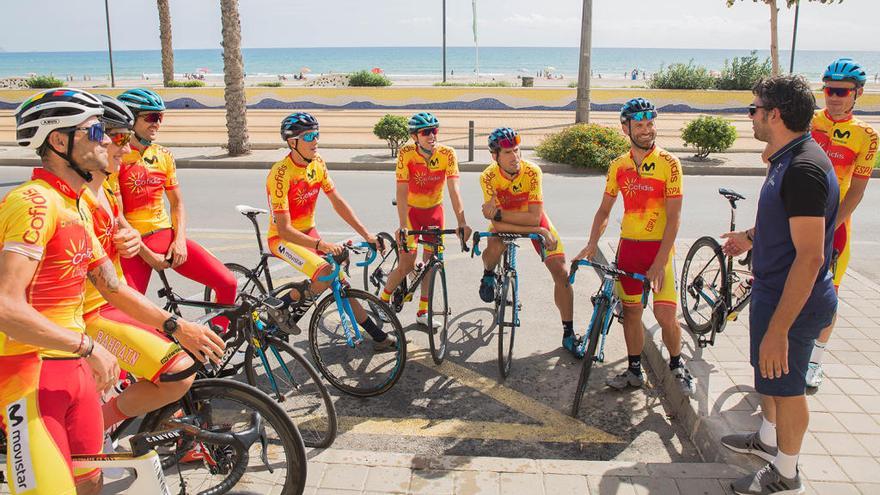 Pascual Momparler habla con los ciclistas antes de un entrenamiento con la playa al fondo