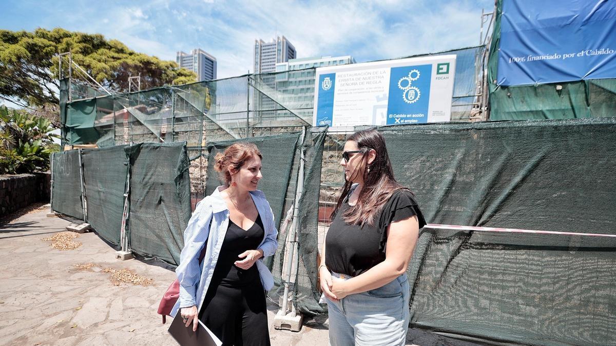 América Quintero, a la izquierda, junto a Sara Felipe, descendientes de vecinos de Los Llanos. Detrás, la ermita de Regla en obras.
