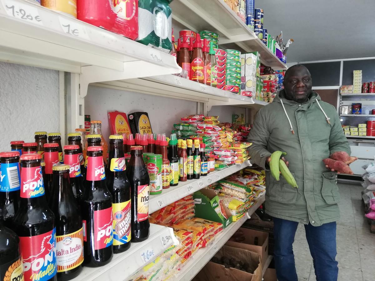 Mamadou Sonoussy Diallo mostra bananes i patata dolça, a la botiga  del carrer de la Trieta