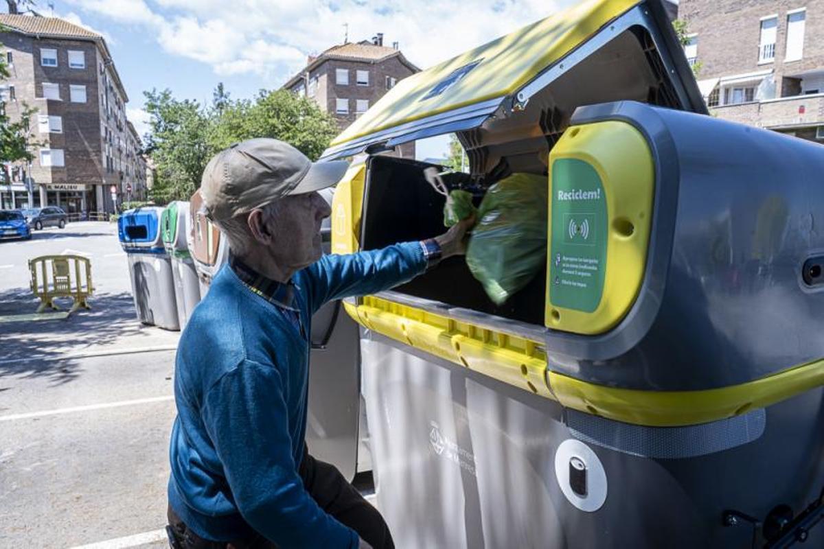 Un usuari llançant envasos al contenidor corresponent, a Manresa