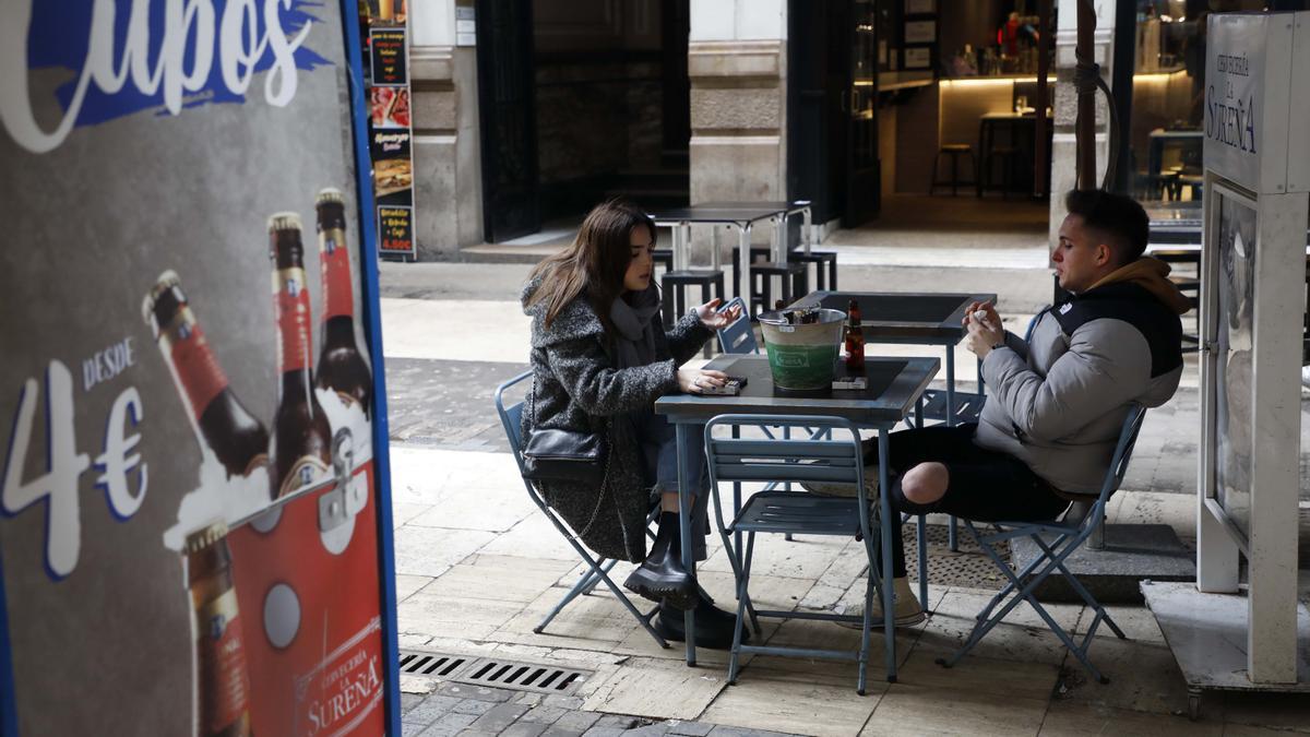 Dos jóvenes tomando una cerveza en el centro de València