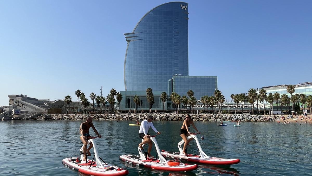 Jordi Donnay (de blanco), durante uno de sus paseos en Bike Surf con el Hotel Vela de fondo.