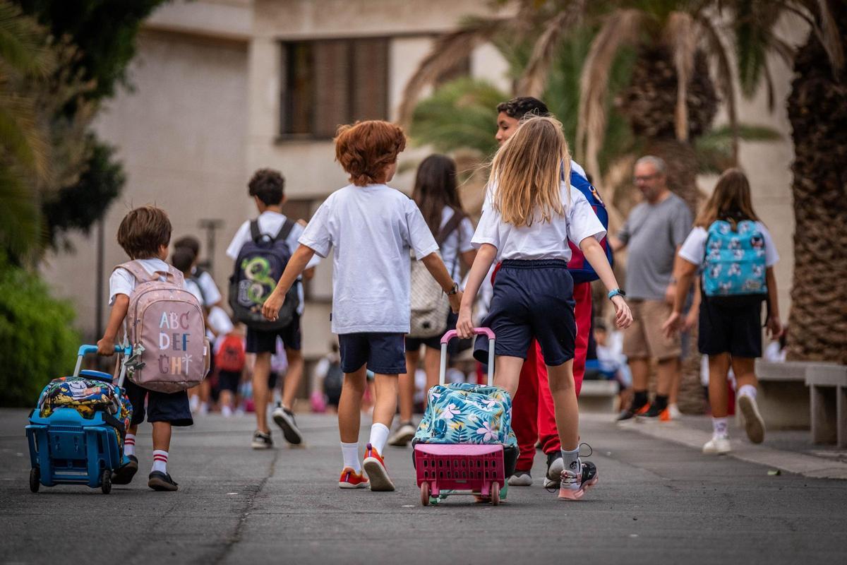 Un grupo de niños en la puerta de un colegio.