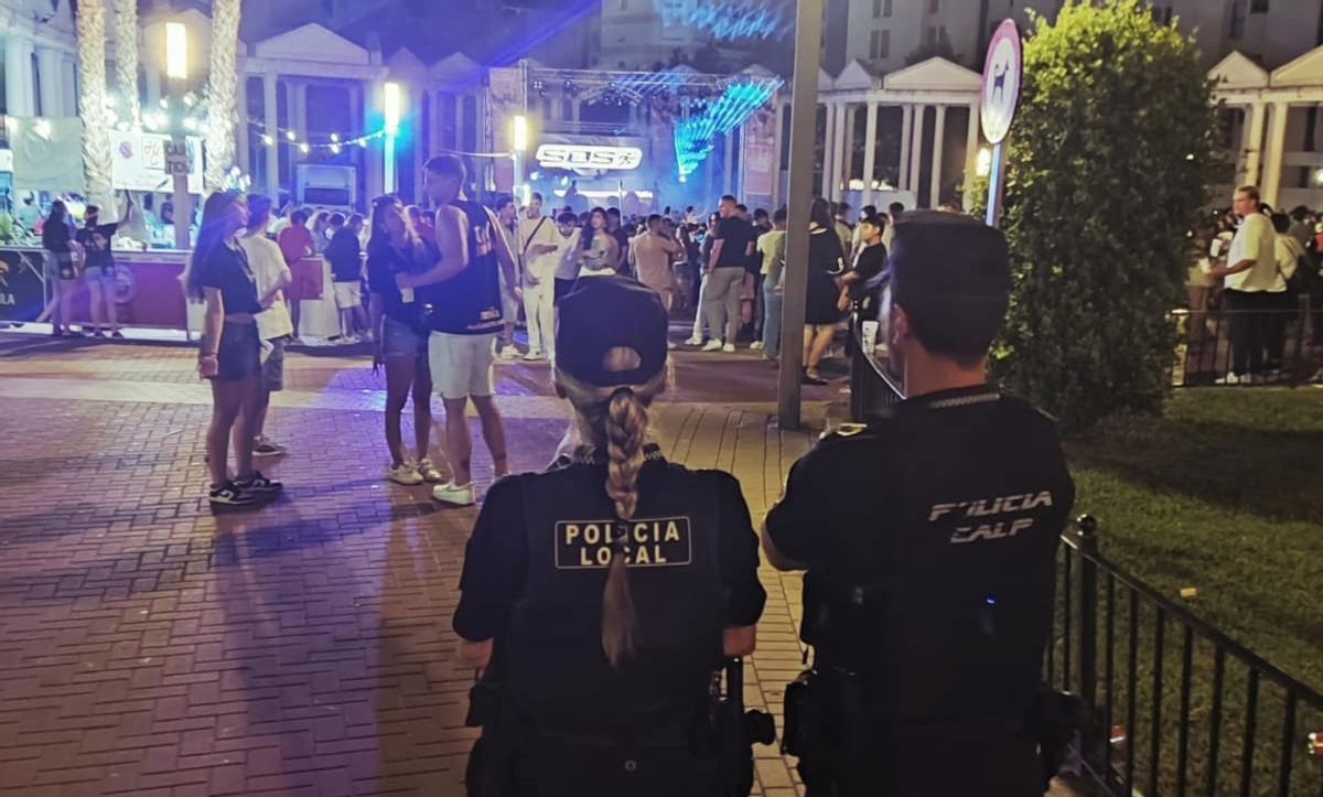 Dos agents de la Policía Local vigilen una festa en el carrer